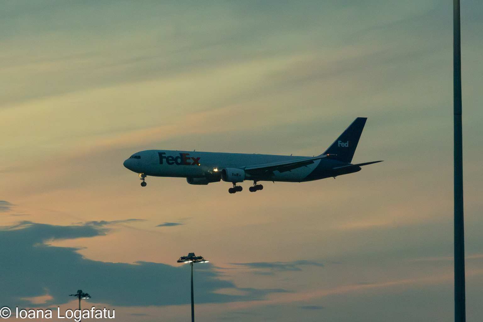 Cargo aircraft descends gracefully at sunset sky